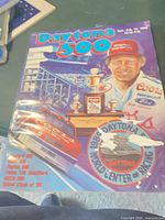 Front cover of 1989 Daytona 500 program showing graphics and damage