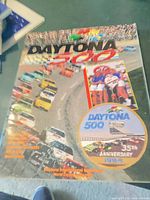 Front cover of the 1994 Daytona 500 program showing race cars and anniversary badge