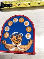 Front of Beaveree embroidered patch next to tape for scale