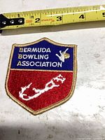 Front view of Bermuda Bowling Association embroidered patch with tape measure for scale