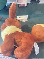 Eevee plush laid flat showing body and attached tags