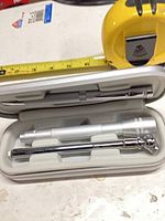 Open case displaying pen, flashlight and telescoping tool