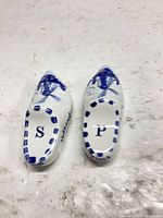 Top view of both clog-shaped shakers showing windmill motif and S/P initials
