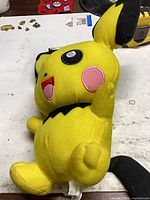 Front angled view of Pichu plush showing face, body and colors