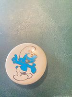 Front of button showing Smurf design and surface condition
