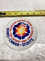 Front of embroidered patch with ruler indicating approximately 4-inch diameter
