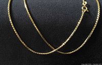 Close view of gold box-link pattern and clasp