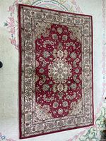Full view of red/burgundy Persian floral area rug on floor