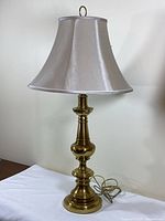 Full view of brass table lamp with shade