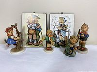 Group shot showing all five figurines and two plaques