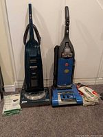Both upright vacuums with accessories and bag pack