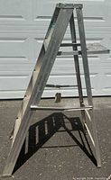 Left side view of aluminum A-frame ladder showing four steps and spreader bar