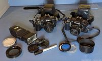Wide shot showing both Minolta Maxxum 7000 cameras, flash, filters and accessories