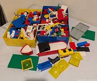 Overview of three trays filled with mixed LEGO pieces, showing baseplates, specialty parts and loose bricks