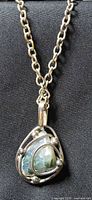 Necklace close-up showing pendant front and chain links