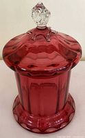 Front view of cranberry glass candy jar with lid on
