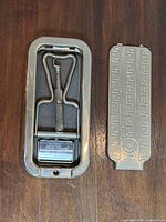 razor mechanism seated in metal case next to lid panel