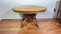 full view of round solid wood pedestal coffee table front and base