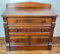 Front view of dresser showing four drawers, carved details, knobs
