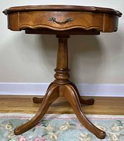 Full view of side table showing top, drawer, pedestal and tripod legs