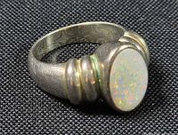 Side view of sterling silver ring showing bezel-set opal and ribbed shoulder design