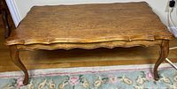 Top view of medium brown veneer coffee table showing scalloped edges and overall finish