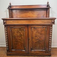 Front view showing overall cabinet, burl doors, barley twist columns, upper gallery shelf