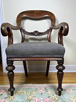 Front view of carved wood armchair showing overall design and upholstery