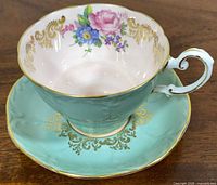Teacup on saucer, interior floral, gilt trim visible