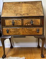Front view showing drop-front closed, drawers, legs