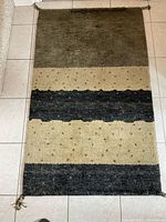 Full view of rug showing striped pattern and overall wear