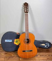 Full front view of Yamaha G-50A guitar leaning against included hard case