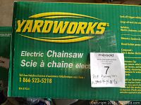 Yardworks branded green box for electric chainsaw, showing Yardworks electric chainsaw text and contact helpline number.
