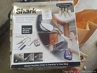 Front view of new in box Shark Multi-Surface Steam Cleaning system packaging showing product features and image of steam pocket in use.