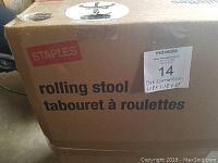 Photo of original boxed packaging showing Staples branding and product description as rolling stool.