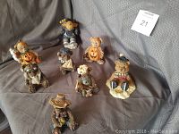 Photo showing the full set of 7 animal figurines including 6 bears and 1 moose positioned on draped fabric.