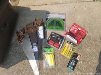 Photo shows three used hand saws with wooden handles, Milwaukee impact driver bit set, Milwaukee flashlight, Haussmann split point drill bits, Haussmann combination hex key set, and other assorted tool accessories.