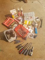 Full lot spread on the floor showing most items clearly including Hickory carbide starter set, screwdrivers, adhesive tubes, organizer box, wires, and assorted screws.