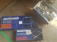 Two boxed Mastercraft branded items: Work Station base and Universal Mobile Base.