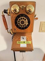 Front view of oak wall phone showing rotary dial marked 1927, brass bells, handset on left, condition of wood and metal