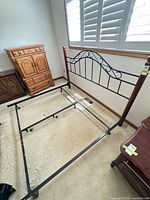 Full view of bed frame showing headboard, footboard, side rails and wooden posts