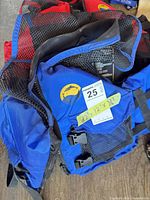 Blue life jacket foreground showing mesh panels, straps, size sticker