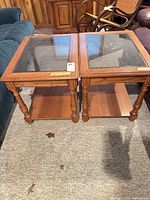 Pair of oak tables showing overall form and glass tops