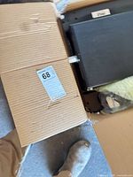Cardboard box showing lot label and packaged speaker