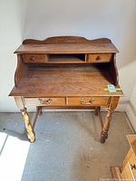 Front view of solid oak writing desk showing overall structure and storage compartments