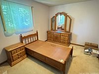 Full view of bed, dresser with mirror, and nightstand in room