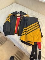Jacket and pants laid out on bed showing overall design and colors