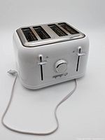 Front and top view of white Sunbeam four-slice toaster showing levers, browning dial and power cord
