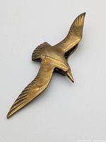 Top view of brass flying bird door knocker, wings spread