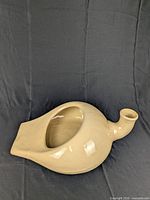 Full view ceramic urinal bedpan showing shape and spout